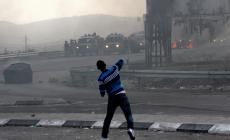 شاب فلسطيني يرشق قوات الإحتلال بالحجارة