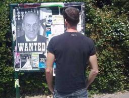  صهيوني ينظر لإعلان وضعت عليه صورة 