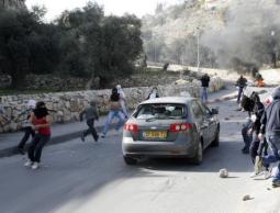  فتية فلسطينيون يلقون الحجارة تجاه سيارة مستوطنين