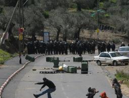 فلسطيني يرشق جنود إسرائيليين بالحجارة 