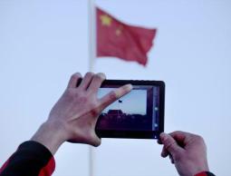  صورة أرشيفية لشخص يلتقط صورة للعلم الصيني