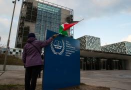 فلسطيني يرفع العلم أمام مقر محكمة الجنايات