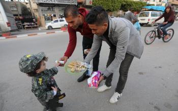 فلسطيني يوزع الحلوى في شوارع مدينة دير البلح بمناسبة عملية مدينة بئر السبع