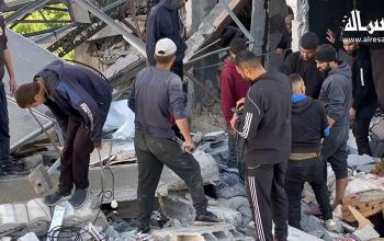 فلسطينيون يتفقدون الدمار بعد الغارة الإسرائيلية على عائلة حطاب