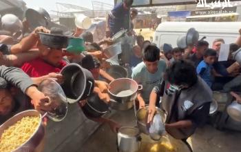 نازحون يتدافعون للحصول على طعام مجاني بمنطقة المواصي في خان يونس جنوب قطاع غزة