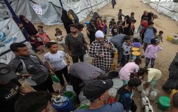 مواطنون يتجمعون للحصول على مياه الشرب في مخيم جباليا المدمر شمال قطاع غزة