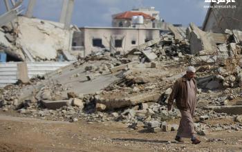 مواطنون يواصلون حياتهم اليومية وسط أنقاض المباني المدمرة في مخيم البريج للاجئين، في قطاع غزة