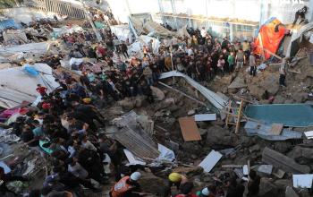 مواطنون يتفقدون الدمار جراء قصف الاحتلال لمدرسة تأوي النازحين في مخيم البريج وسط قطاع غزة