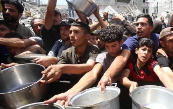 نازحون يتزاحمون للحصول على ما يتوفر من طعام مجاني لسد جوعهم في مخيم جباليا شمال قطاع غزة