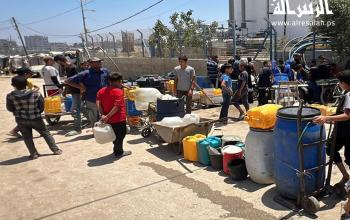 مواطنون ينتظرون الحصول على المياه من أحد الآبار المتبقية في مخيم النصيرات وسط قطاع غزة