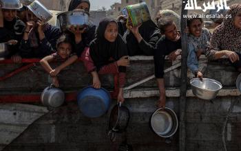 مواطنون يتزاحمون للحصول على قليل من الطعام تقدمه تكية خيرية في مدينة غزة