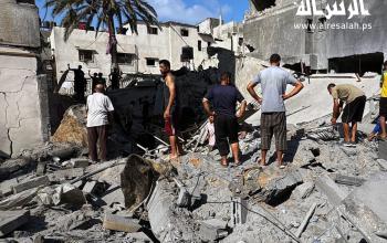 مواطنون يتفقدون آثار الدمار بعد غارة جوية اسرائيلية على منازل المواطنين في دير البلح وسط قطاع غزة