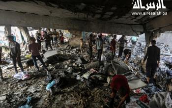 مواطنون يتفقدون الدمار جراء القصف الاسرائيلي على مدرسة تؤوي النازحين في مدينة غزة
