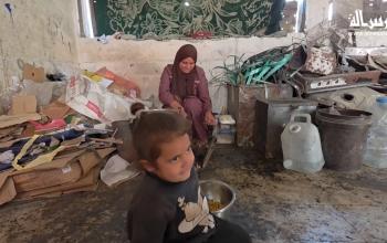 امرأة فلسطينية تأوي مع أطفالها داخل مدرسة مدمرة قرب خط التماس الأصفر شرق خان يونس