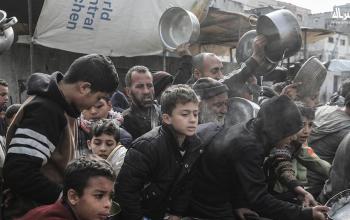 نازحون يتجمعون للحصول على طعام مجاني في مخيم النصيرات