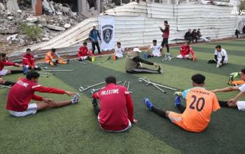 فريق غزة الإرادة لذوي البتر يقوم بتمرين رياضي على أرض ملعب جنوب مدينة غزة