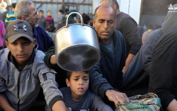 نازحون يتجمعون لتلقي إفطار رمضاني من تكية خيرية في مخيم النصيرات