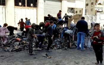 أطفال يبحثون بين مخلفات حريق مواد غذائية في غزة