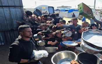 نازحون يتجمعون للحصول على وجبات طعام من مطبخ خيري في خان يونس