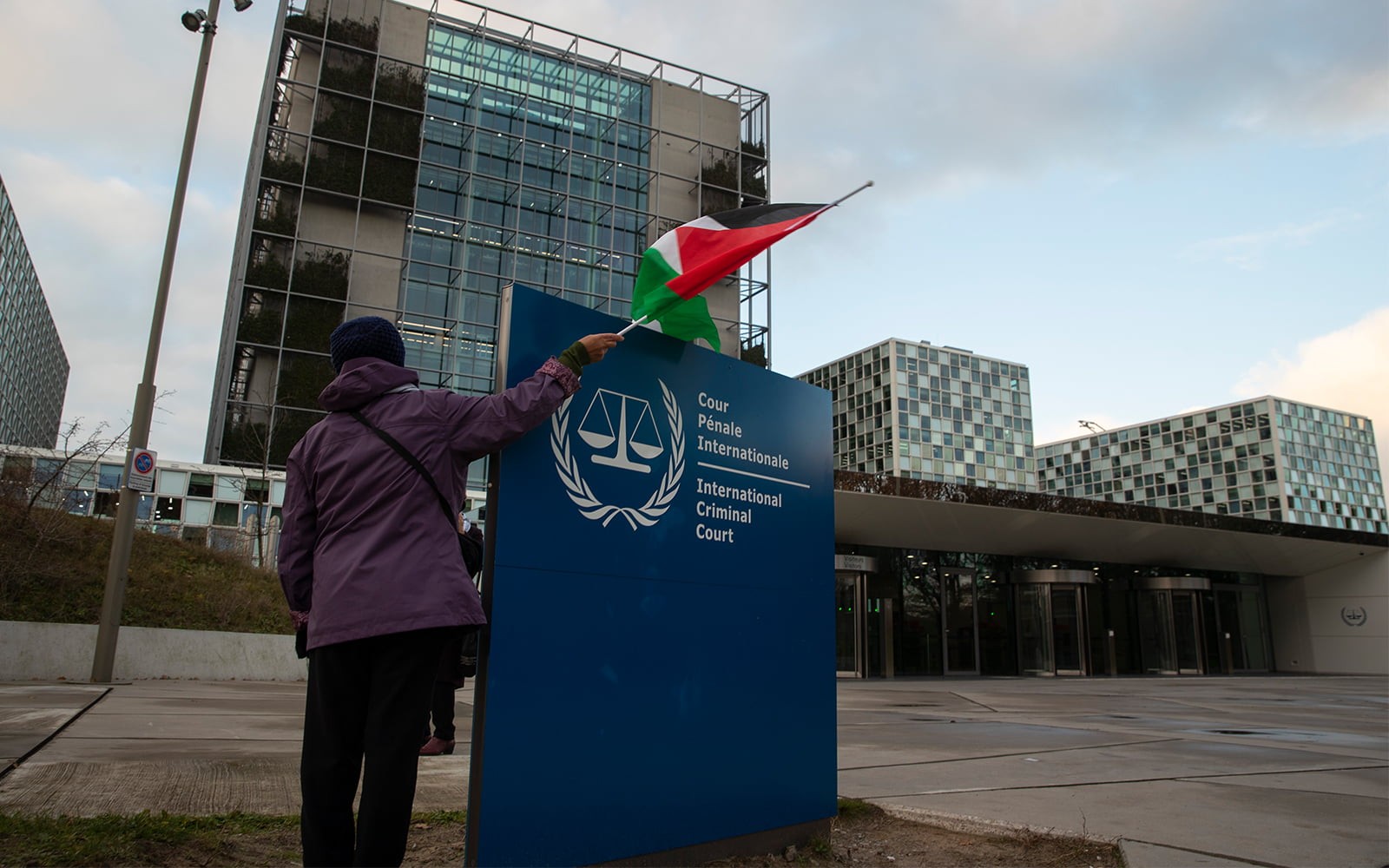 فلسطيني يرفع العلم أمام مقر محكمة الجنايات