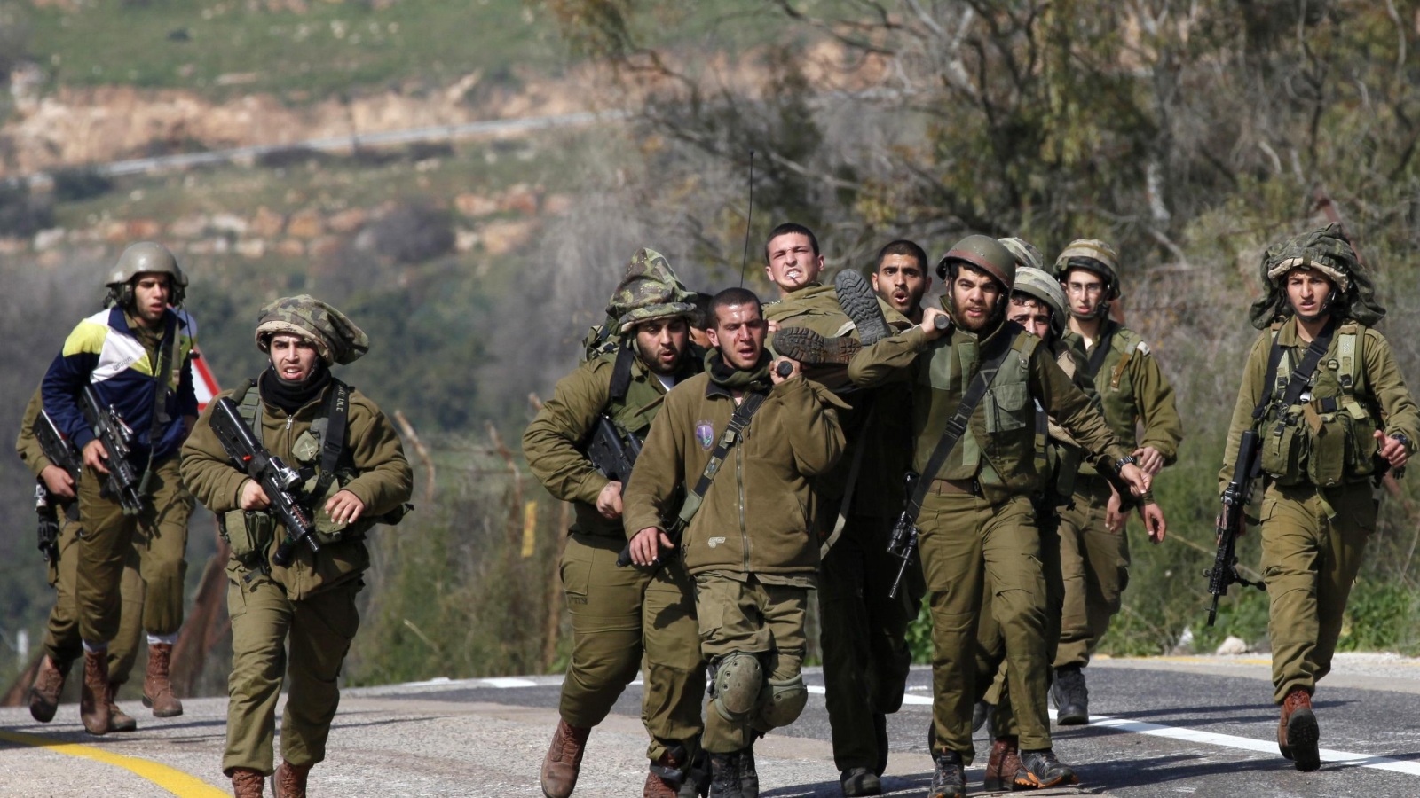 جنود إسرائيليون يحملون جريحا بعد هجوم صاروخي لحزب الله