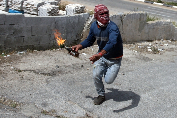 شاب فلسطيني يلقي زجاجة حارقة على الاحتلال (أرشيف)